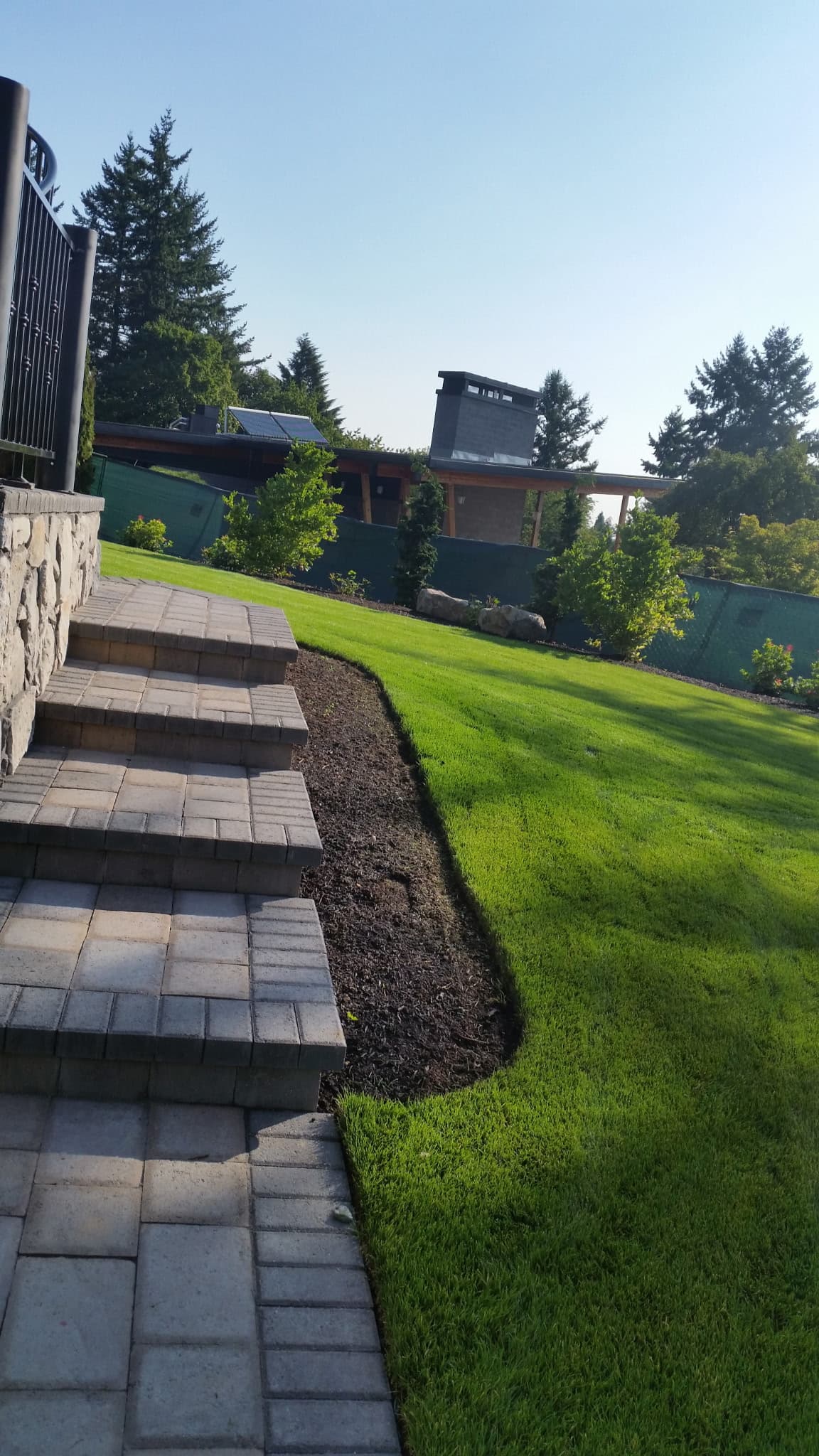 A completed JMC paver installation meeting a clean lawn edge.